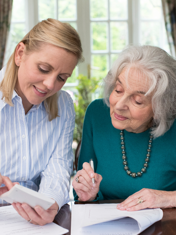 Adult daughter assisting elderly mother with long-term care insurance paperwork